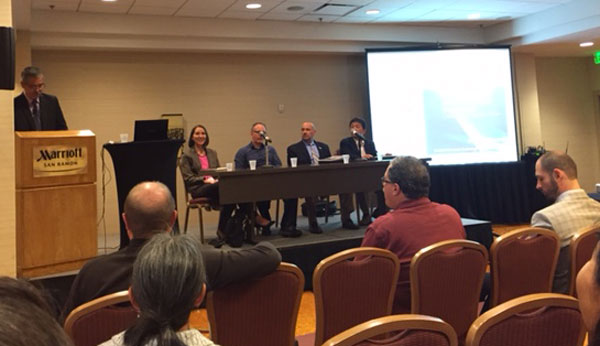 Randy Iwasaki, executive director of the Contra Costa Transportation Authority, at the lectern, moderates a panel discussing on autonomous vehicles. Guest speakers included